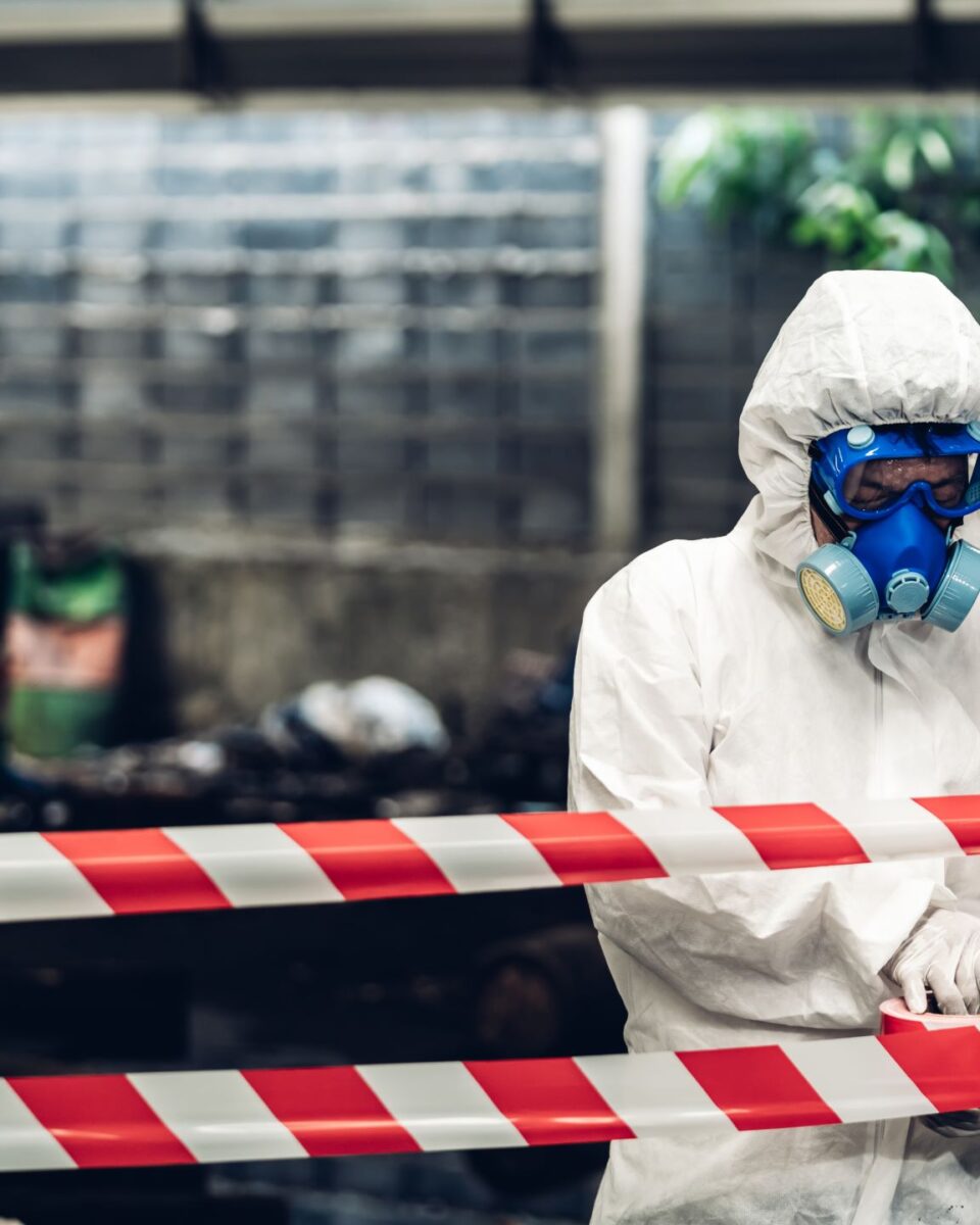 Scientist wear Chemical protection suit check danger chemical, working at dangerous zone in Red and White Lines of barrier tape. Red and white Hazardous restricted area factory safety worker industry